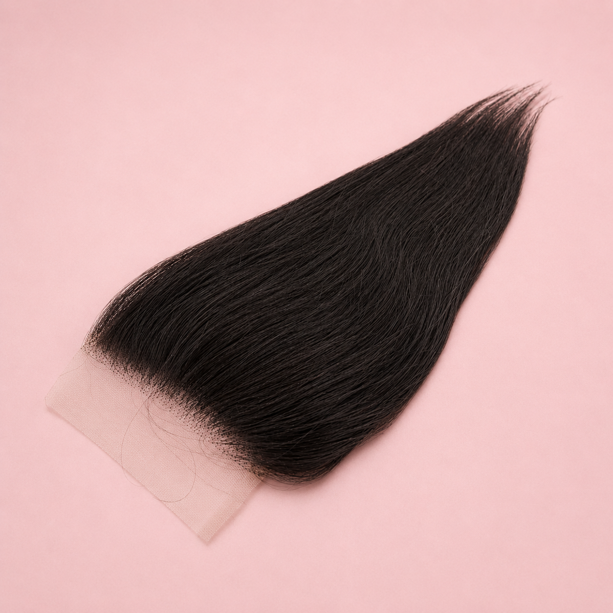 Black hair extension on a pink background