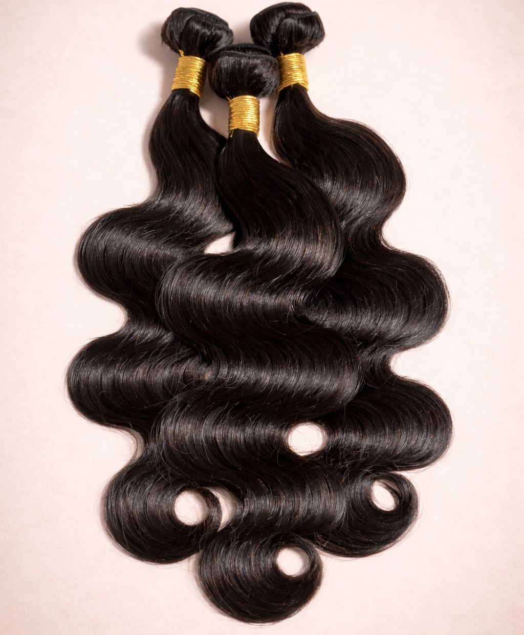 Three bundles of black hair extensions on a beige background
